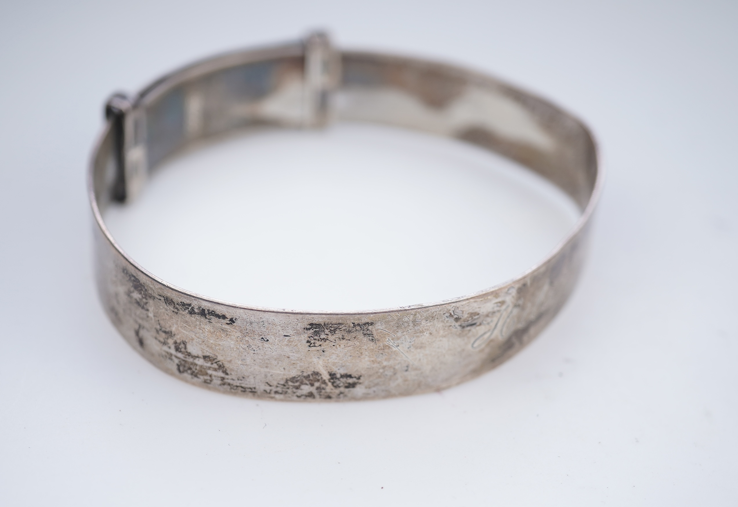 A collection of silver jewels, comprising: a bangle; a chain necklace suspending two winding toothpicks, one with toothpick deficient; a rope twist chain; a pair of cufflinks with the initials DBH; a pendant of abstract